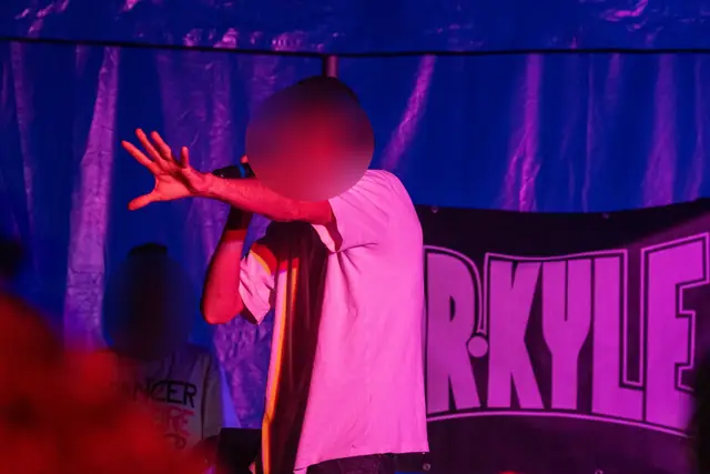 Dr Kyle raps on stage under purple light