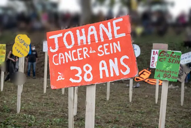 A red sign, “Johane, breast cancer at 38” (“Johane, cancer du sein à 38 ans”), planted in the cemetery of public health