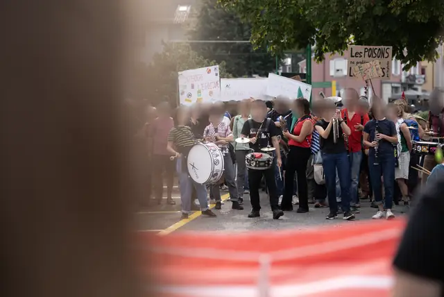 A brass band plays at the front of the march through the streets of Monthey