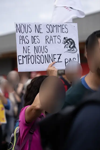 A sign reading “We are not rats, don’t poison us!” (“Nous ne sommes pas des rats, ne nous empoisonnez pas !”)