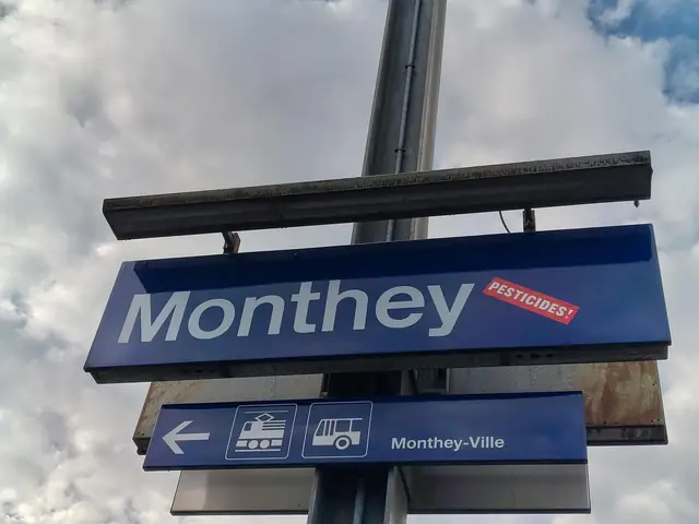 The Monthey station sign with a “Pesticides!” (“Pesticides !”) sticker on it